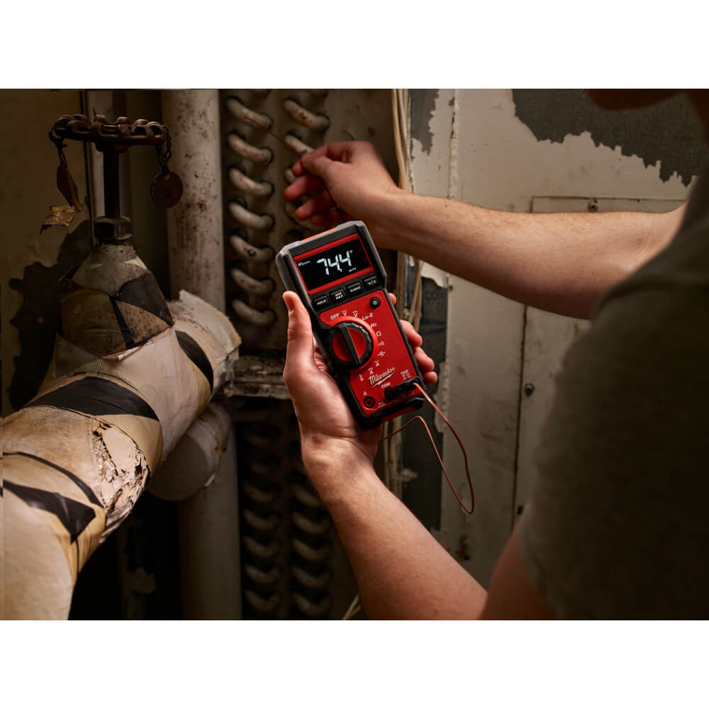 Electrician testing a panel with a Milwaukee multimeter