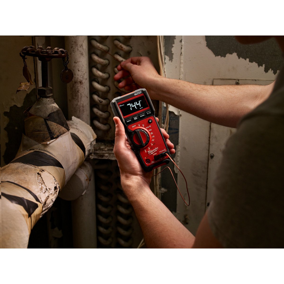 Electrician testing a panel with a Milwaukee multimeter